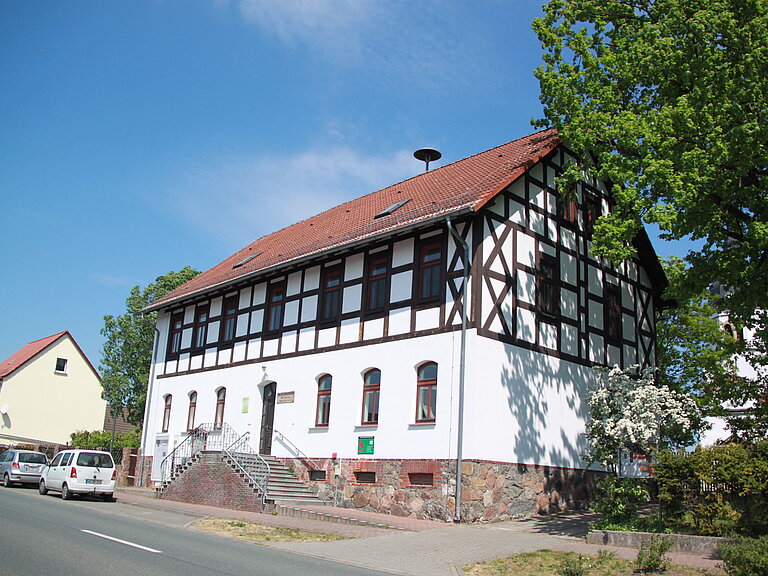 ehemalige Heideschule direkt an der Straße - heute ist ein Dorfgemeinschaftshaus, davor Parktaschen