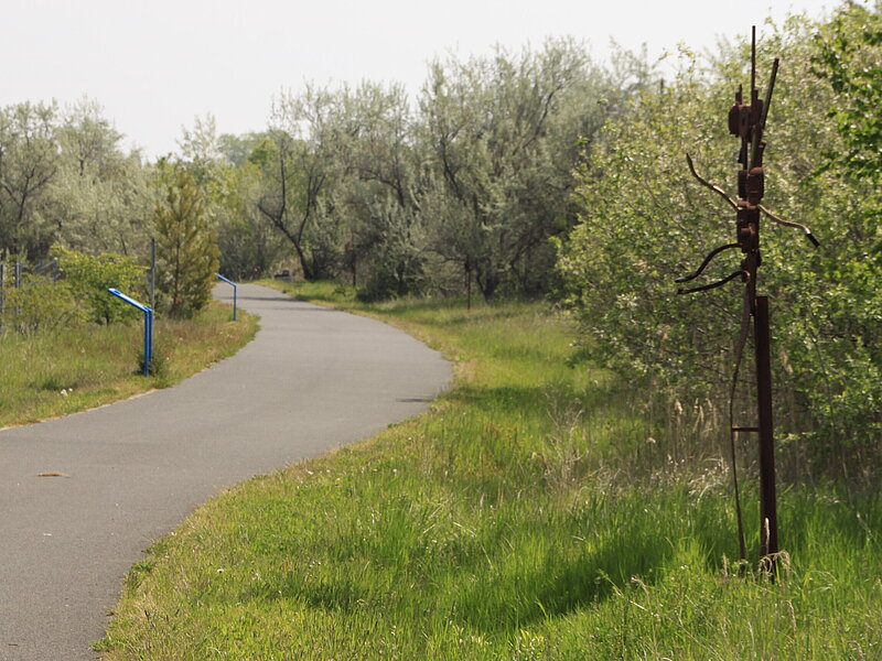 Radweg und Schrottplastik entlang des Kunstpfades am Gremminer See