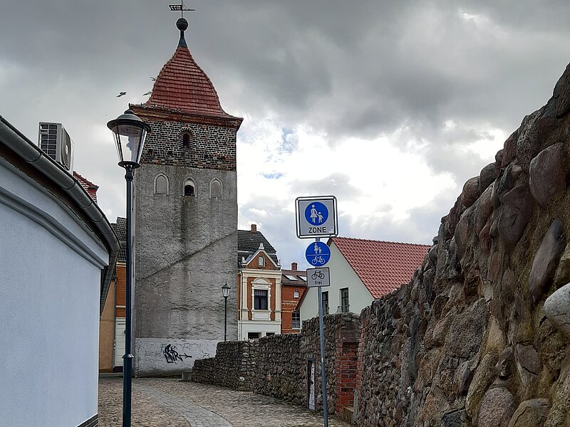 kleiner Teil der Stadtmauer mit Kopfsteinpflasterweg. Im Hintergrund befindet sich der Obere Stadtturm.
