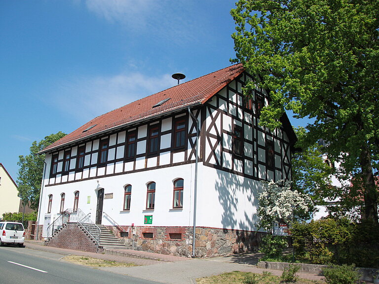 ehemalige Heideschule direkt an der Straße - heute ist ein Dorfgemeinschaftshaus, davor Parktaschen