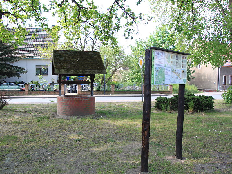 Dorfmitte mit Hinweistafel zu Schköna und Brunnen