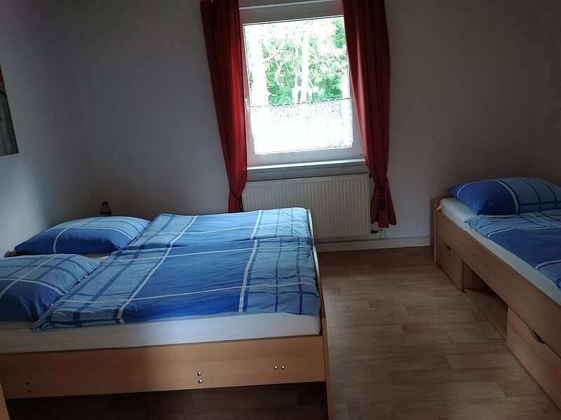 Schlafzimmer mit Doppelbett und Einzelbett Ferienwohnung 4