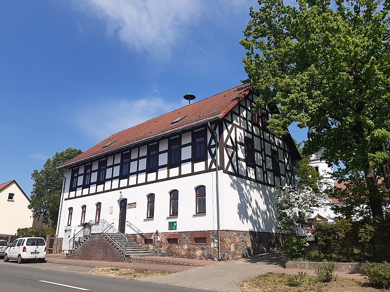 ehemalige Heideschule direkt an der Straße - heute ist ein Dorfgemeinschaftshaus, davor Parktaschen