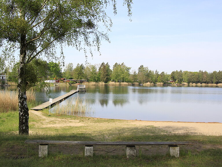 Strandbad Möhlau mit Blick auf den See, Steg und Sprungturm.