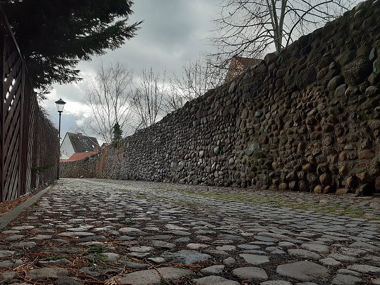 kleiner Teil der Stadtmauer mit Kopfsteinpflasterweg