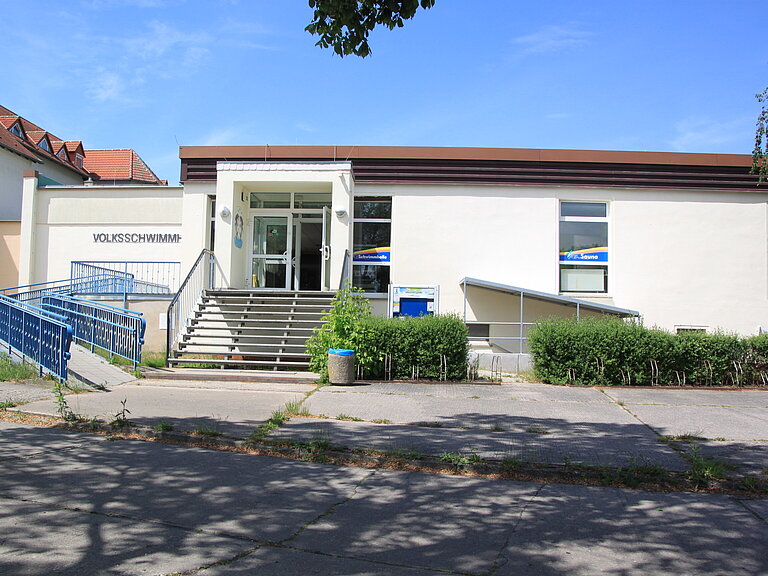 Treppe und Barrierefreier Eingang in die Schwimmhalle. Davor gibt es Fahrradabstellmöglichkeiten.
