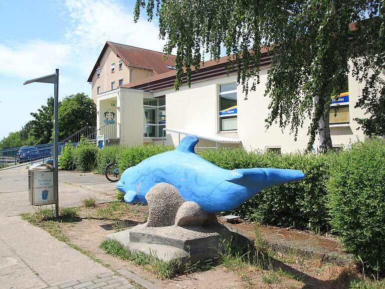 Blick vom blauen Stein-Delphin Richtung Eingang der Schwimmhalle.