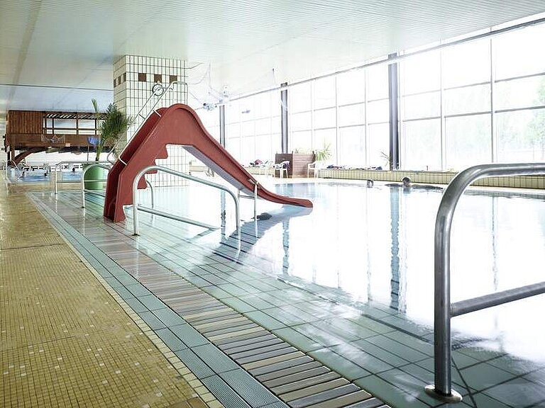 Nicht-Schwimmbecken mit roter Rutsche.