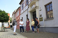 Eine Stadtführung macht einen informativen Halt am historischen Rathaus.